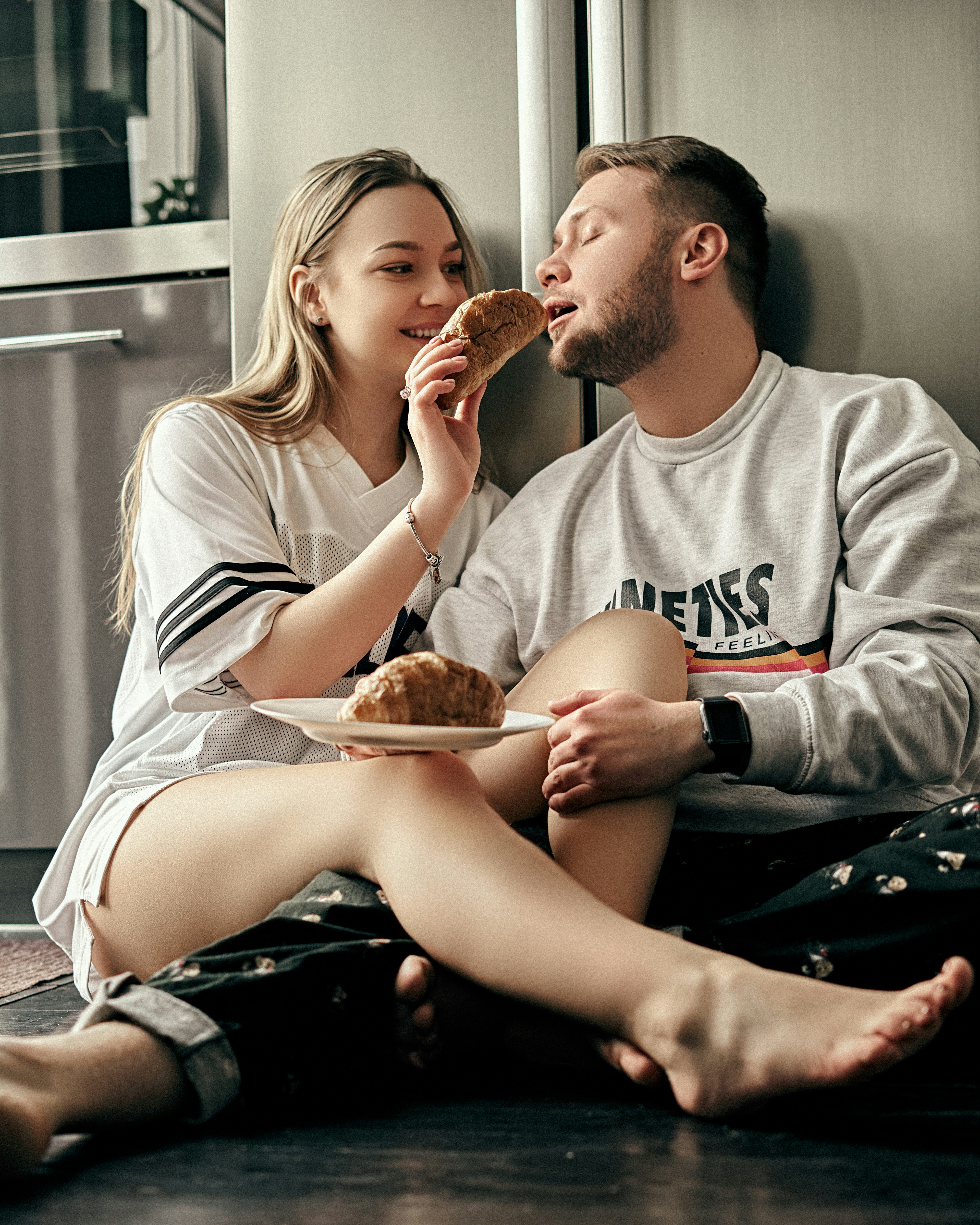 man and woman sitting on black leather couch